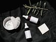brown glass bottles on black textile beside gua sha and leaves